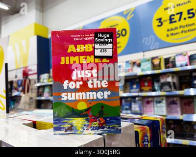 Manchester, Royaume-Uni - 26 septembre 2025 : juste pour l'été par Abby Jimenez présenté sur une étagère de librairie avec une couverture colorée. Banque D'Images