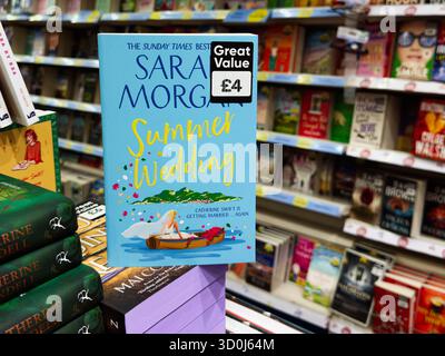 Manchester, Royaume-Uni - 26 septembre 2025 : couverture de livre du mariage d'été par Sarah Morgan exposée dans une librairie lumineuse. Banque D'Images
