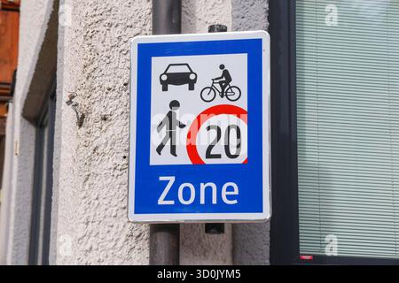 23.10.2025, Handenberg, AUT, Unterwegs in Oberösterreich, Themenbild, Symbolbild, Verschiedene Themenbilder, Verkehrszeichen, im Bild Das Bild zeigt ein Verkehrsschild in einer blauen und weißen Farbgestaltung. Es enthält folgende symbole Ein Auto, Ein Fahrradfahrer, Eine gehende person, Unter diesen Symbolen befindet sich ein roter Kreis mit der Zahl 20 , was auf eine Geschwindigkeitsbegrenzung von 20 km/h hinweist. AM unteren Rand des Schildes steht das Wort zone .Das Schild dient dazu, die Geschwindigkeit in einem bestimmten Bereich zu regulieren und auf die Anwesenheit von Fußgängern und R Banque D'Images
