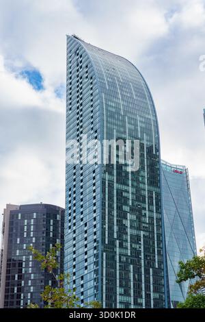 Le gratte-ciel l Tower avec son design distinctif en verre incurvé s'élève contre un ciel nuageux dans le quartier du centre-ville. Banque D'Images