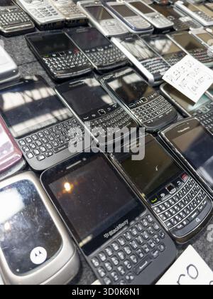 Collection de téléphones mobiles BlackBerry vintage et fonctionnels disposés sur une table, mettant en vedette les modèles classiques des smartphones du début des années 2000 Banque D'Images