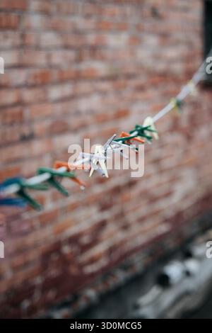 Pinces à linge colorées sur la ligne contre le mur de briques Banque D'Images