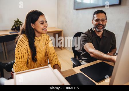 Deux architectes, une jeune femme et un homme d’âge moyen, travaillant ensemble dans un cadre professionnel. Banque D'Images