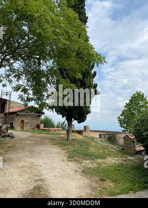 Une vue panoramique d'un site historique en Géorgie, avec des bâtiments en pierre avec des portes voûtées et des toits de tuiles rouges. Banque D'Images