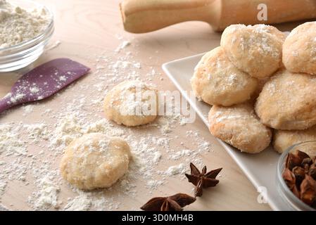 Détail de biscuits à l'anis fraîchement cuits sur un banc en bois avec des ustensiles de cuisine, de la farine et de l'anis étoilé sur un banc en bois. Vue surélevée. Banque D'Images