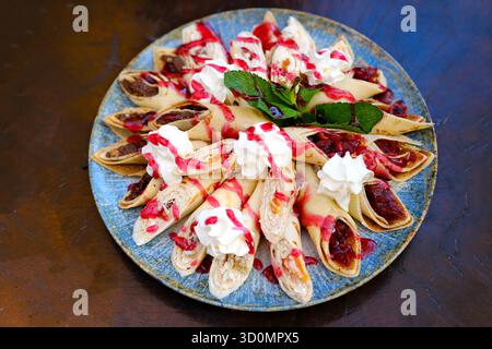 Crêpes farcies de chocolat à tartiner et de banane sur assiette blanche. Crêpes fines, blini. Dessert sucré. Photo de haute qualité Banque D'Images