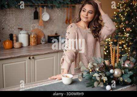 Femme dans Cozy Kitchen avec décor de Noël Banque D'Images