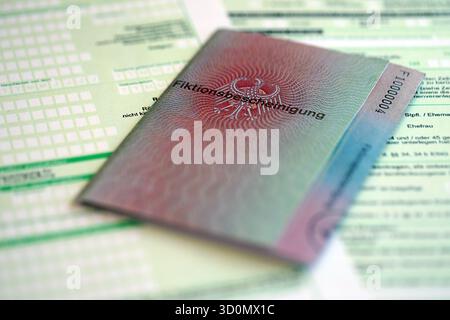 Le spécimen de carte de résident permanent temporaire allemand se trouve sur le formulaire fiscal allemand close up. Fiktionsbescheinigung et einkommensteuerklarung Banque D'Images