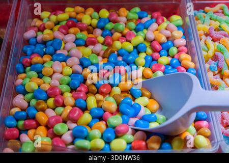 bonbons dragées multicolores présentés pour la vente sur un comptoir de magasin Banque D'Images