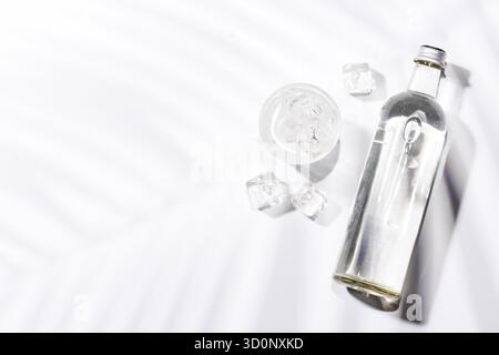 Verres transparents remplis d'eau fraîche et de glaçons, élégamment présentés sur fond blanc éclatant, dégageant fraîcheur et simplicité Banque D'Images