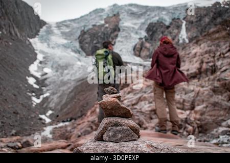 Un glacier au sommet de la montagne. Deux hommes en trekking ont grimpé jusqu'au glacier. Banque D'Images