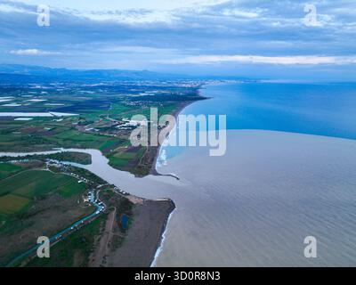 Antalya, Turquie - 13 juillet 2024 : vue aérienne haute montrant un fleuve qui rencontre la mer Méditerranée, avec des champs et un développement côtier le long du rivage Banque D'Images