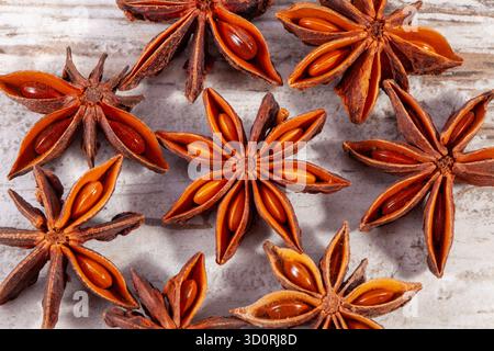 Groupe de petites étoiles d'anis séché (Illicium verum) sur planche de bois, gros plan Banque D'Images