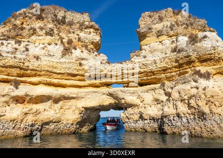 Visitez avec un petit bateau à moteur la côte rocheuse de Ponta da Piedade, un paysage côtier accidenté situé juste à côté du centre-ville de Lagos dans l'ouest de Al Banque D'Images