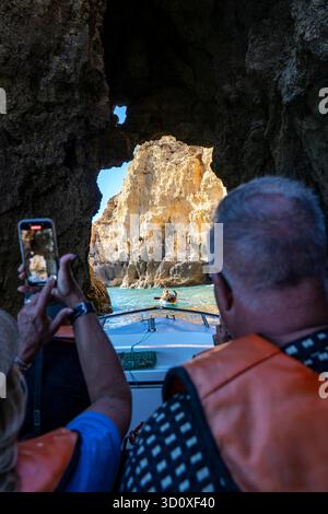 Visitez avec un petit bateau à moteur la côte rocheuse de Ponta da Piedade, un paysage côtier accidenté situé juste à côté du centre-ville de Lagos dans l'ouest de Al Banque D'Images