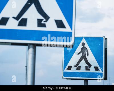Deux panneaux de passage pour piétons sont bien en vue en Suède, guidant les gens sur les endroits où traverser en toute sécurité. Les signes comportent des symboles clairs à promouvoir Banque D'Images