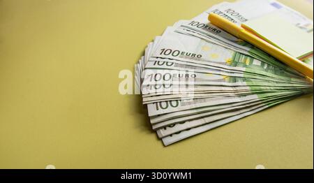 Pile de cent billets en euros avec stylo jaune et bloc-notes symbolisant la planification financière et le succès commercial Banque D'Images