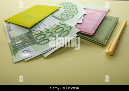 Cent billets en euros avec stylo jaune et bloc-notes sur fond doré Banque D'Images