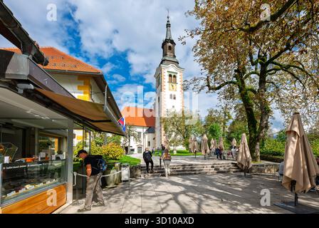 Cafés et boutiques dans un petit espace de parc sous l'église de l'Assomption de Marie sur l'île de Bled, sur le lac à Bled Slovénie. Banque D'Images