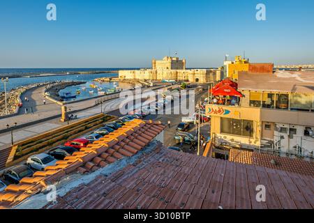 La Citadelle de Qaitbay le long de la mer Méditerranée le long de la promenade balnéaire de Qaitbay au coucher du soleil à Alexandrie, Egypte. Banque D'Images