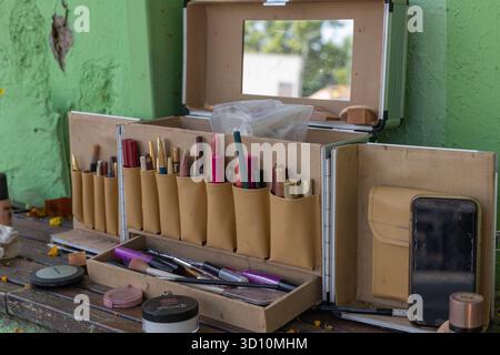 Kit de maquillage professionnel ouvrant, révélant divers cosmétiques et outils prêts pour une routine beauté sur une table en bois rustique Banque D'Images