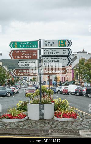 Panneaux routiers bilingues en gaélique et en anglais regroupés sur un poteau en République d'Irlande Banque D'Images