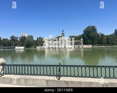 Monument Alfonso XII dans le parc du Retiro, Madrid, avec sa colonnade grandiose et sa statue reflétées dans le lac par une journée ensoleillée d'été. Banque D'Images