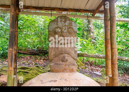 Ancienne statue en pierre entourée de verdure luxuriante à San Agustin, Huila, Colombie, un site classé au patrimoine mondial de l'UNESCO mettant en vedette la culture précolombienne Banque D'Images