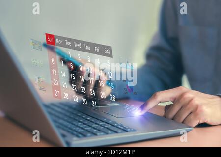 Calendrier pour les rendez-vous mensuels et la planification, gestion de son horaire d'affaires, main marquant les dates sur le calendrier virtuel Banque D'Images