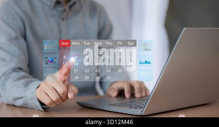 Calendrier pour les rendez-vous mensuels et la planification, gestion de son horaire d'affaires, main marquant les dates sur le calendrier virtuel Banque D'Images