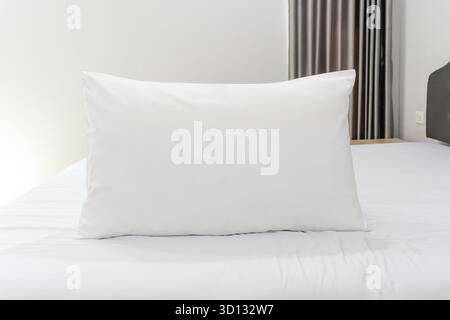 Un oreiller blanc et un lit avec matelas ont été pris dans la chambre de villégiature ou d'hôtel. Banque D'Images