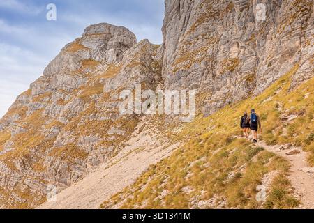 9 septembre 2025, parc Durmitor, Monténégro : les gens marchent sur un sentier de montagne avec des sacs à dos, marchent vers le haut sur un chemin rocheux Banque D'Images