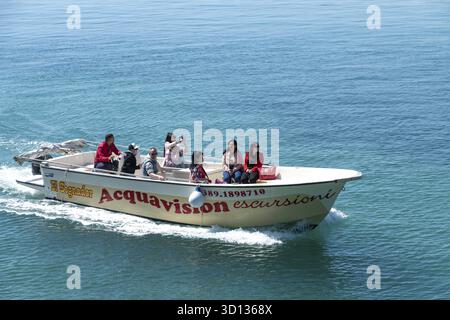 Syrakus, Sizilien - Italie - 04-09-2025 : bateau d'excursion avec des passagers naviguant dans l'eau turquoise claire près de Syracuse, labellisé 'Acquavision escursion Banque D'Images