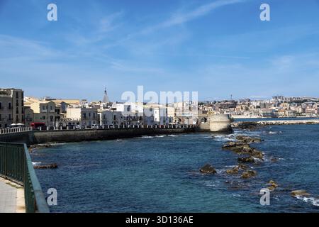 Syrakus, Sizilien - Italie - 04-09-2025 : vue panoramique sur la côte de Syracuse avec ses bâtiments historiques en bord de mer, sa digue et ses eaux bleues profondes Banque D'Images