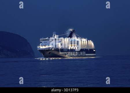 Olbia - Sardinien - Italien - 2025 : illuminé Grimaldi Lines ferry Cruise Europa traverse la mer près d'Olbia la nuit, réfléchissant la lumière Banque D'Images