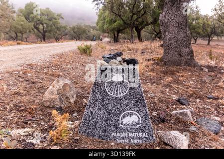 Marqueur en granit avec une coquille Saint-Jacques et logo parque Natural sierra norte indiquant la route Camino de Santiago de la via de la Plata à travers un natu Banque D'Images