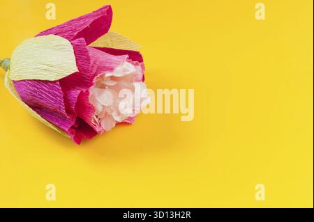 Fleurs en papier ondulé maison sur fond jaune Banque D'Images