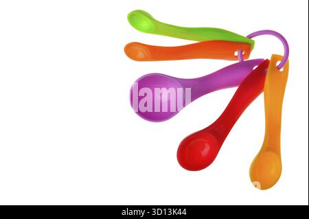 Cuillères à mesurer en plastique multicolore en grammes isolées sur blanc Banque D'Images