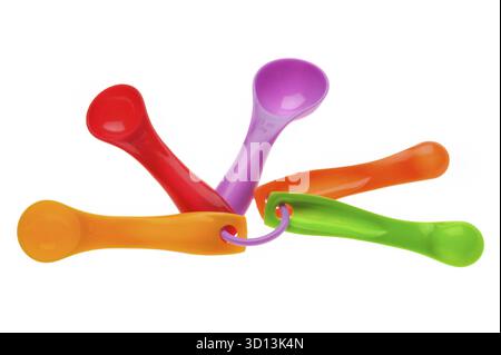 Cuillères à mesurer en plastique multicolore en grammes isolées sur blanc Banque D'Images
