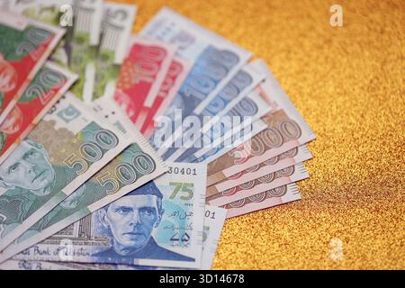 Pakistan roupies billets de banque sur fond jaune doré. Les factures d'argent pakistanaises actuelles sont sur la table en gros montant. Le concept d'affaires et d'investissement au Pakistan Banque D'Images
