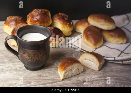 Petits pains et tartes et verre d'argile avec du lait Banque D'Images