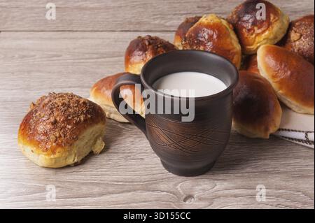 Petits pains et tartes et verre d'argile avec du lait Banque D'Images