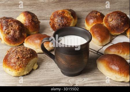 Petits pains et tartes et verre d'argile avec du lait Banque D'Images
