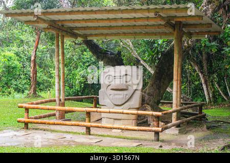 Une statue en pierre unique abritée au parc archéologique de San Agustin, présentant l'art précolombien entouré d'une végétation luxuriante. Banque D'Images