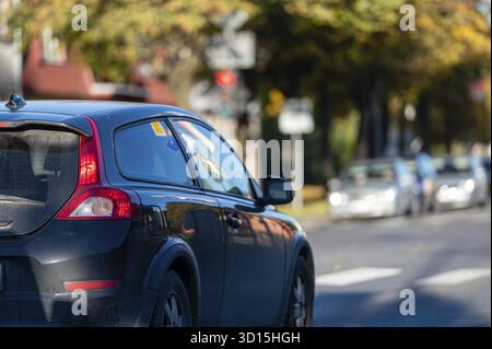 Les voitures se déplacent sur la route en ville. Vue sur le trafic avec les panneaux, les feux de circulation et le véhicule Banque D'Images
