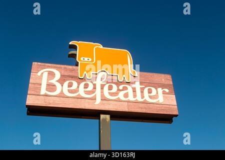 Enseigne de restaurant Beefeater avec un logo de vache orange stylisé sur une planche de bois contre un ciel clair dans whitley Bay tyne & Wear Banque D'Images