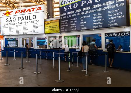 Marilia, SP, Brésil. 26 septembre 2025. Les passagers font la queue pour acheter des billets dans une gare routière animée au Brésil. Les panneaux situés au-dessus des comptoirs indiquent l'itinéraire Banque D'Images
