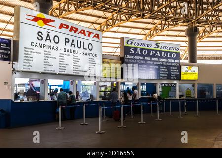 Marilia, SP, Brésil. 26 septembre 2025. Les passagers font la queue pour acheter des billets dans une gare routière animée au Brésil. Les panneaux situés au-dessus des comptoirs indiquent l'itinéraire Banque D'Images