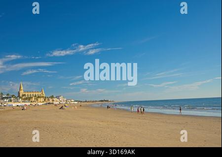 Plage de Regla avec église et phare à Chipiona dans la lumière chaude du soir Banque D'Images