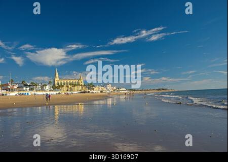 Plage de Regla avec église et phare à Chipiona dans la lumière chaude du soir Banque D'Images